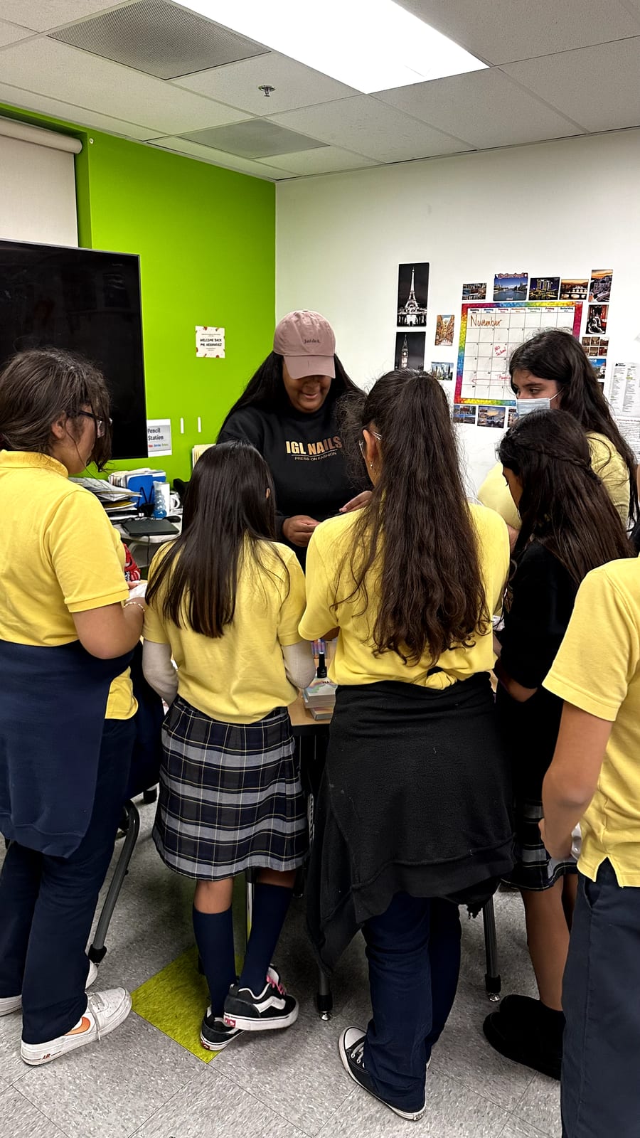 Students gathered around an instructor during a hands-on press-on nail demonstration