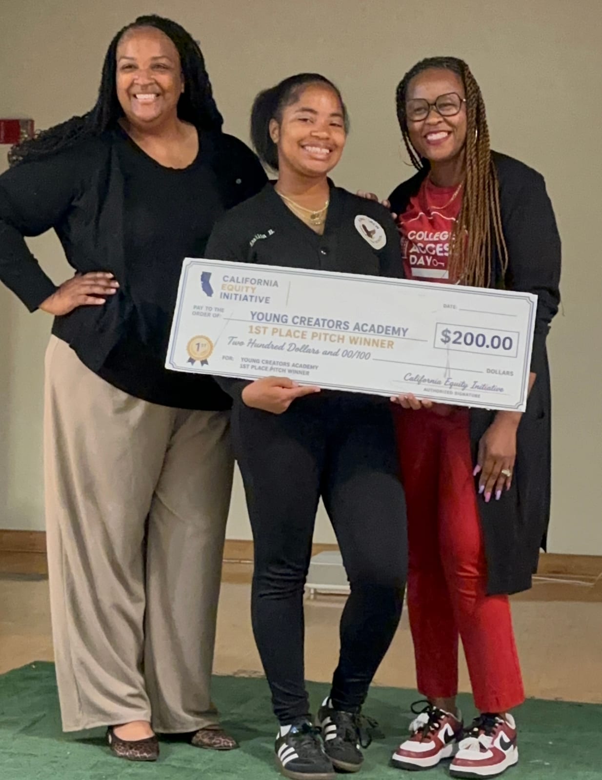 A student holding the first place pitch competition check for Young Creators Academy